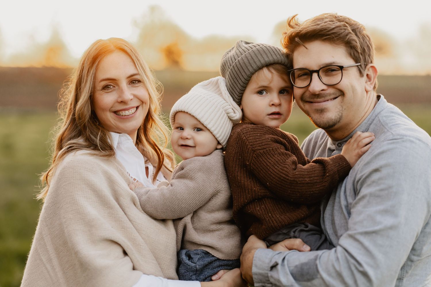 Familienfotoshooting Niederösterreich Outdoor, Familie bei Sonnenuntergang mit 2 Kindern auf dem Arm