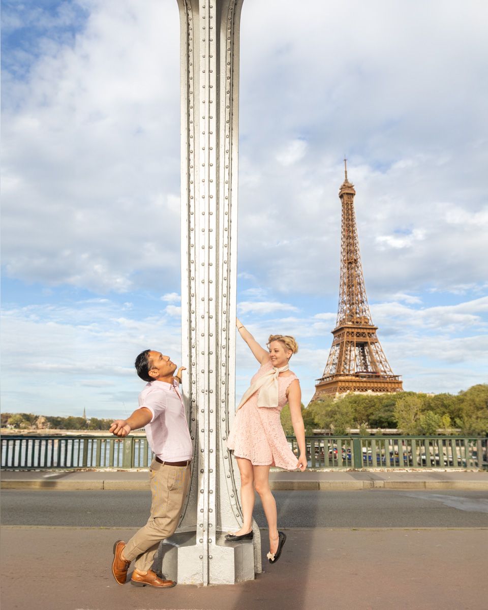 A playful pose near a pillar with the iconic Eiffel Tower in the background.