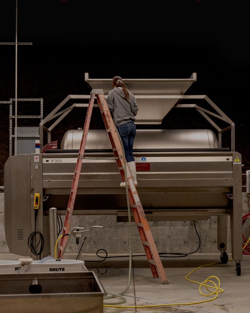 Assistant Winemaker Lauren cleaning a press at Peake Ranch in Santa Barbara Wine Country