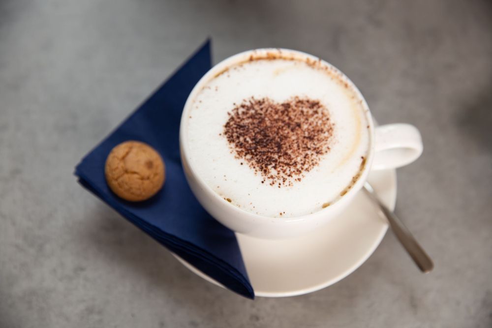 coffee with a heart on top and biscuit