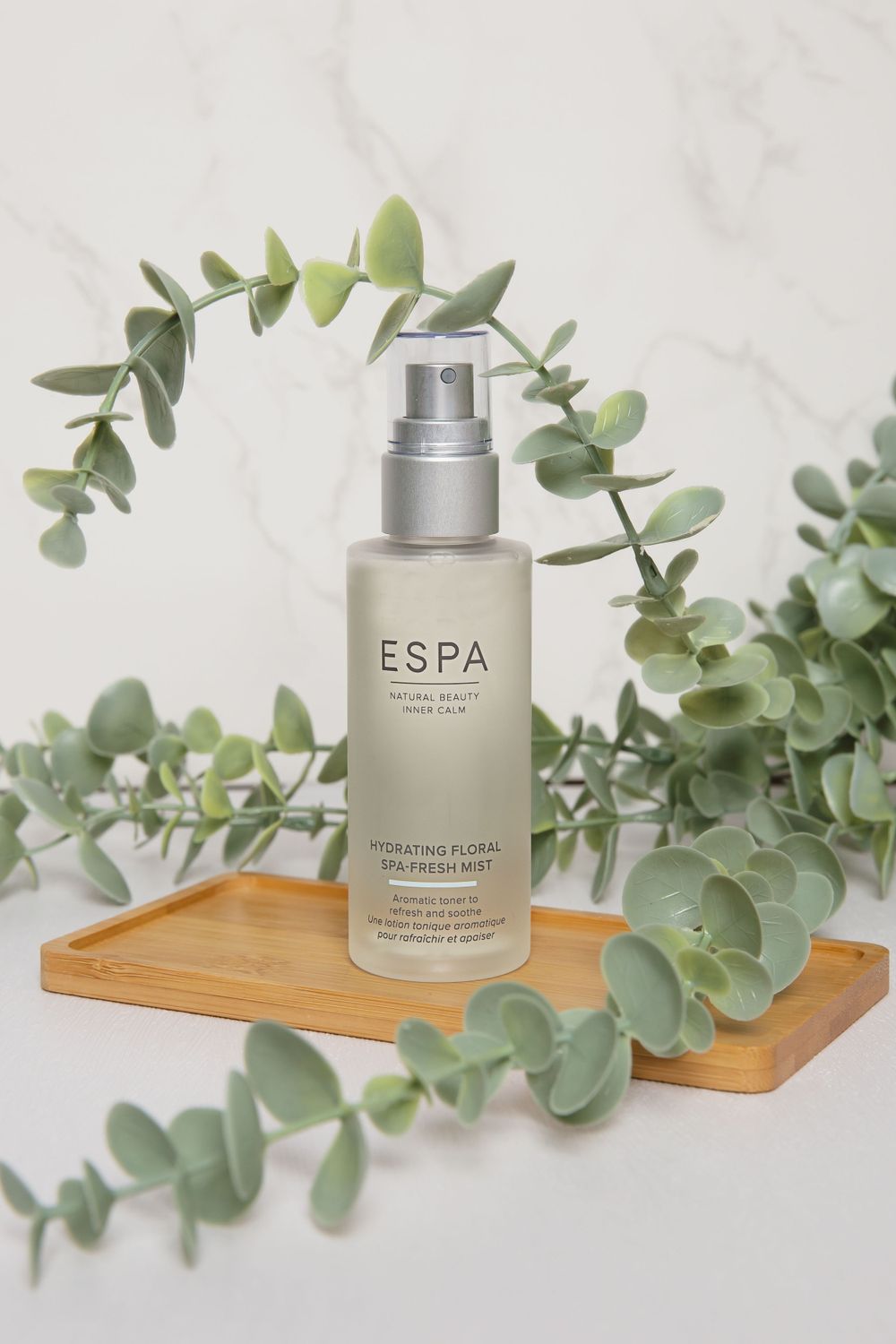 espa clear spray bottle on wooden tray with leaves surrounding