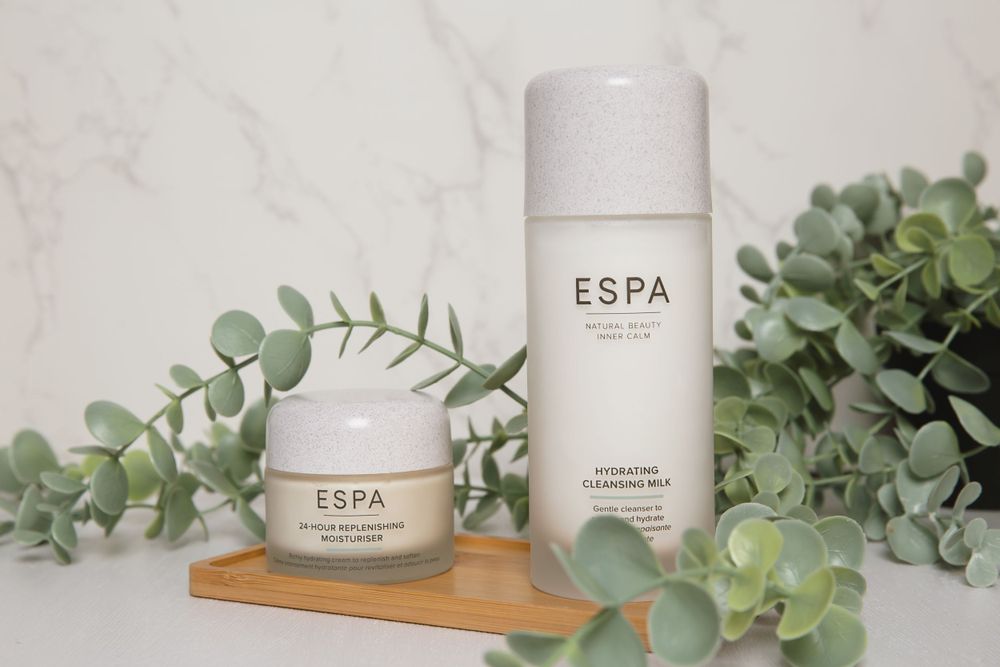espa cream large and small bottle on wooden tray surrounded by leaves