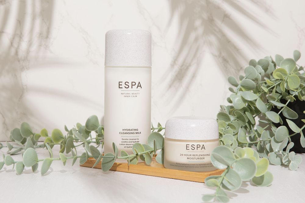 product photo of espa cream bottles on a wooden tray with a plant and shadow of leaves in the background