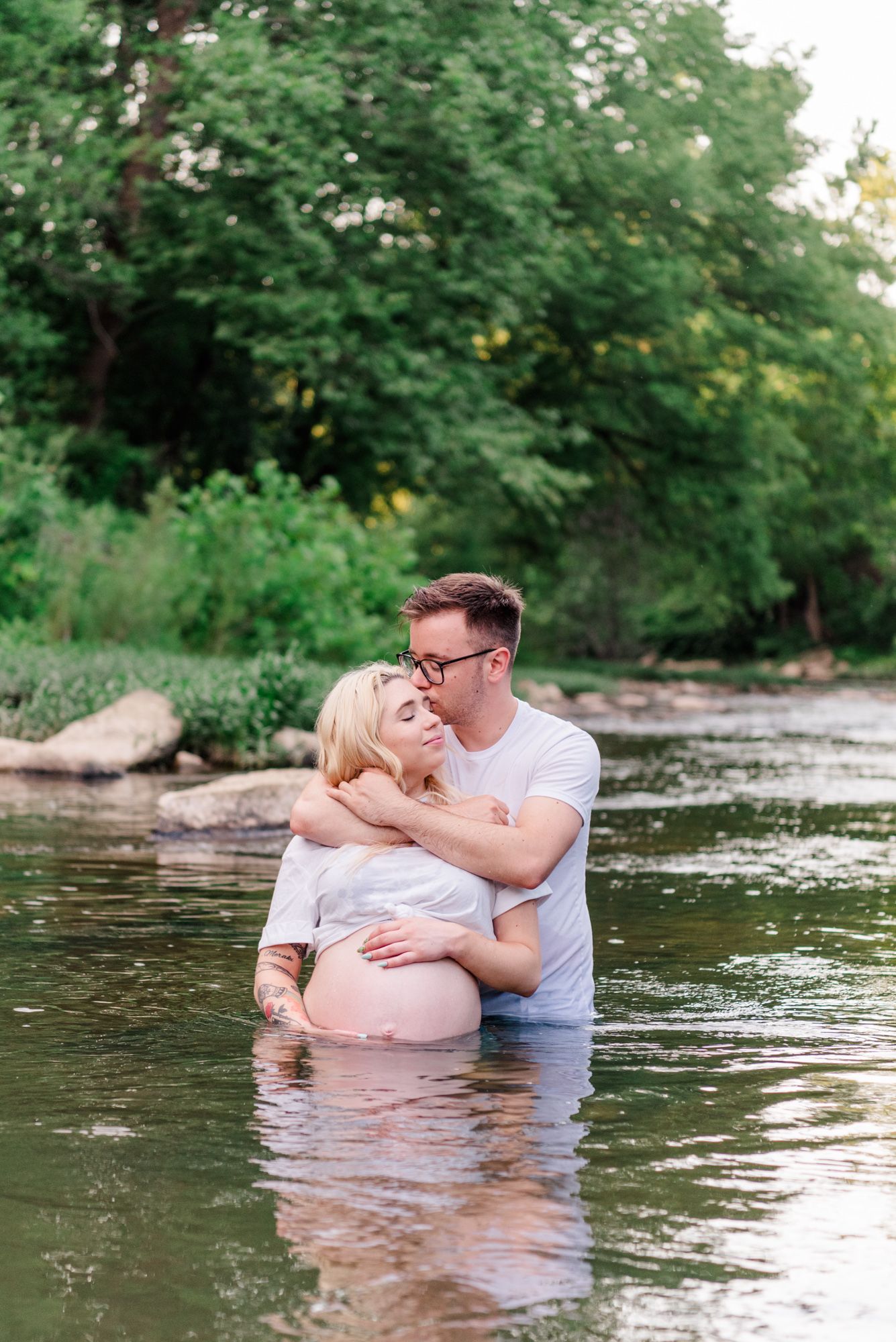 Nontraditional maternity photos in jeans and white shirt in stream in Harmony, Pennsylvania