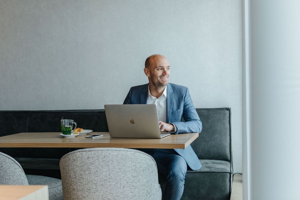 Man in pak is aan het werk achter zijn laptop