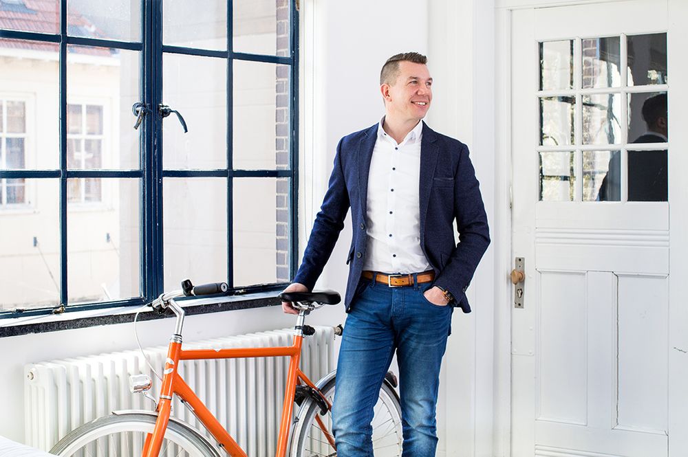 Man met een fiets naast het raam