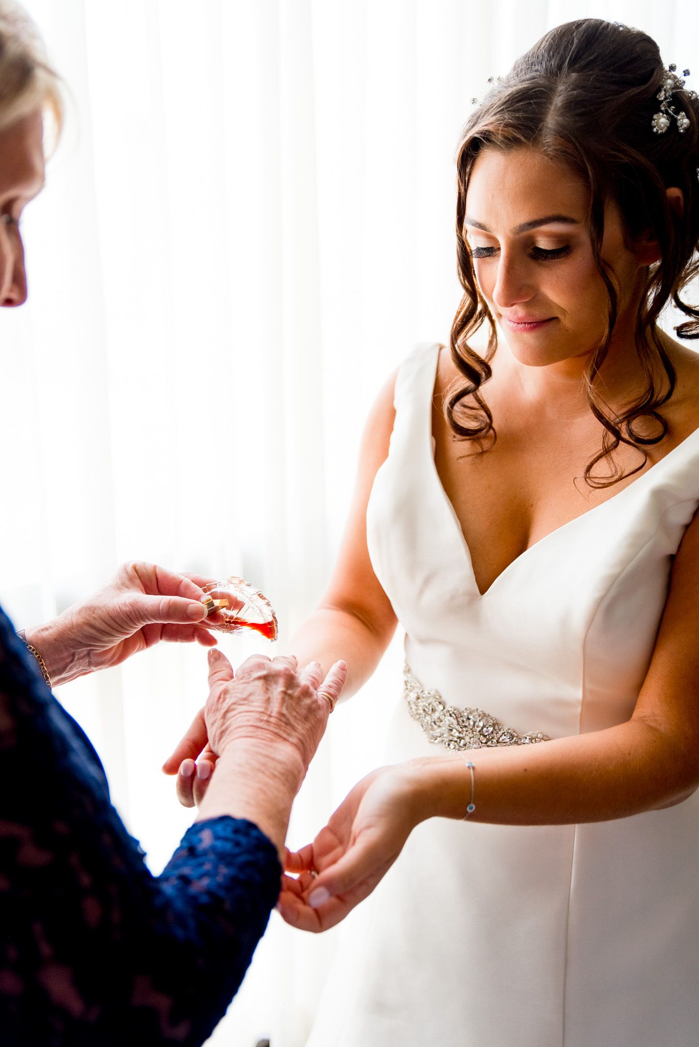 bride puts on vintage perfume before her fall chicago wedding ceremony