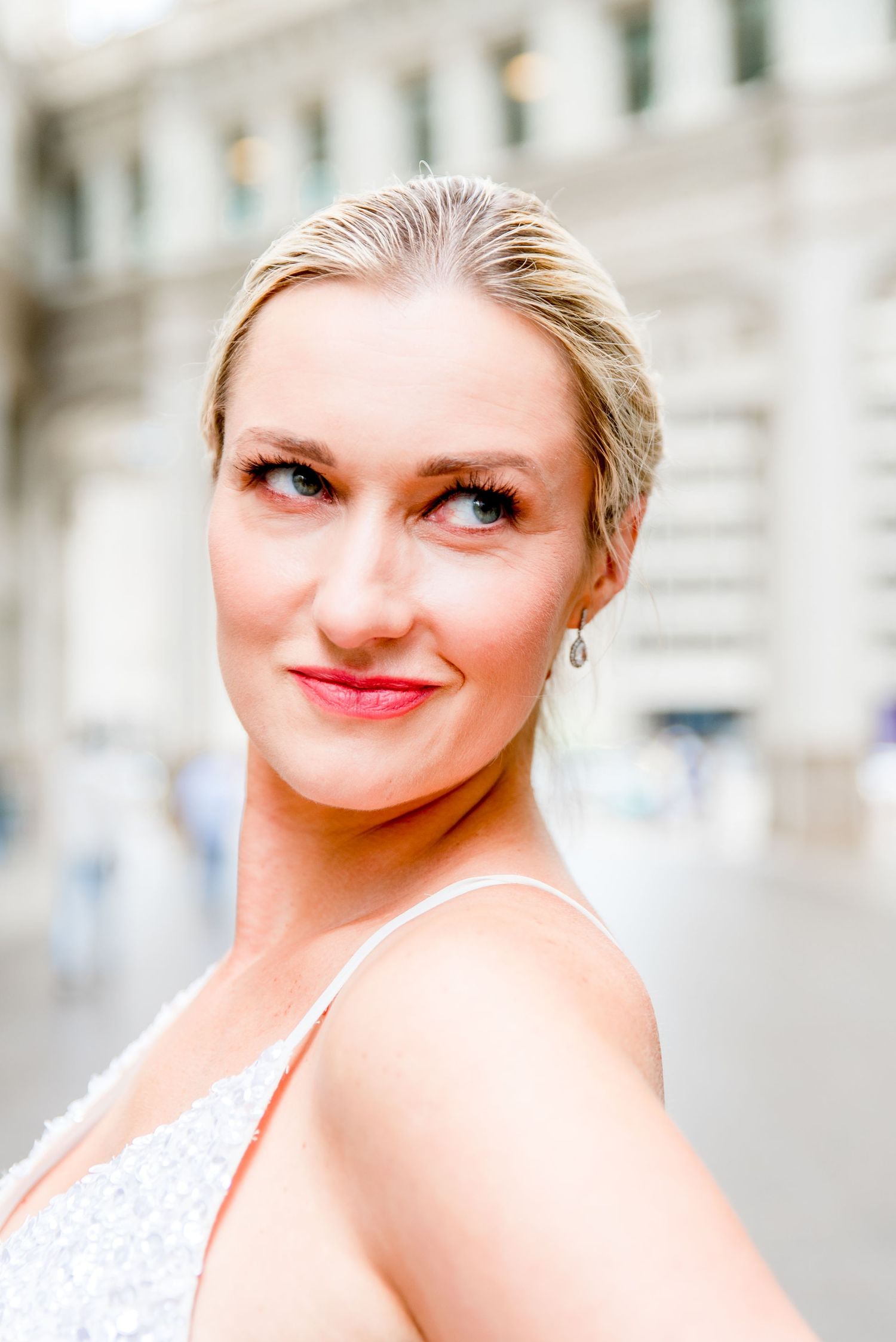 blonde woman in silver sequin dress under Wrigley Building after downtown Chicago elopement
