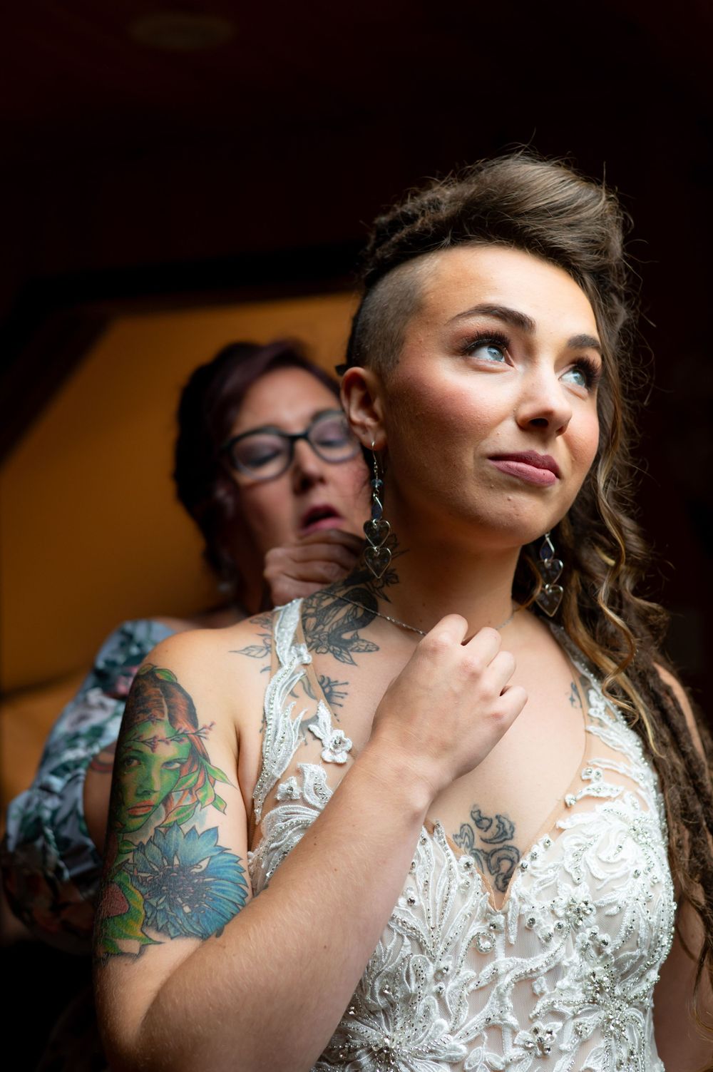 A detailed shot of intricate lace wedding dress and visible tattoo artwork.