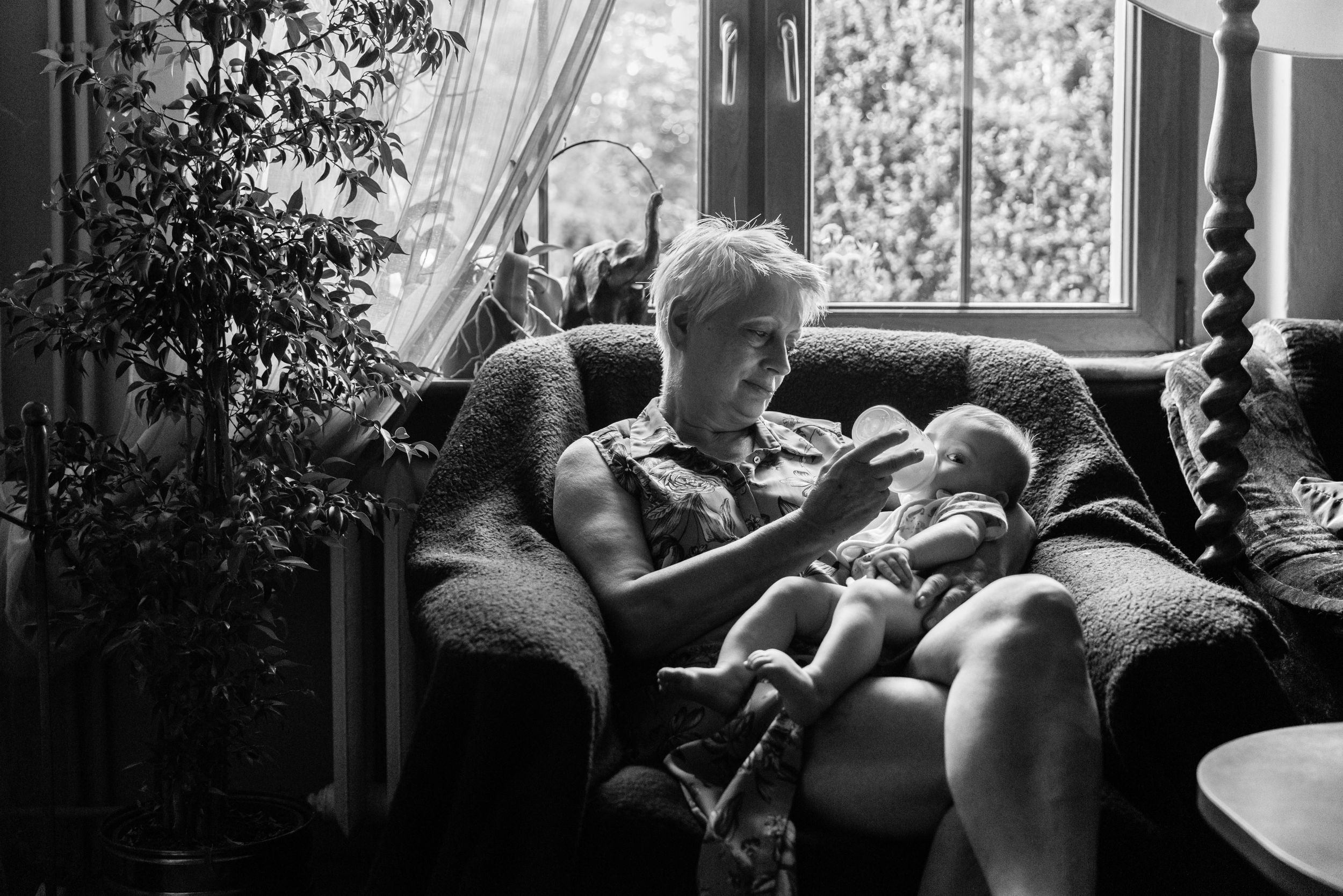grandmother bottle feeding milk baby girl