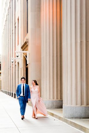 young engaged man and woman holding hands smiling and walking near Chicago Board of Trade