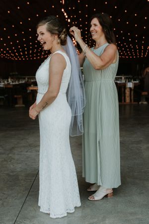Bride with a huge smile and her mom fixing her veil
