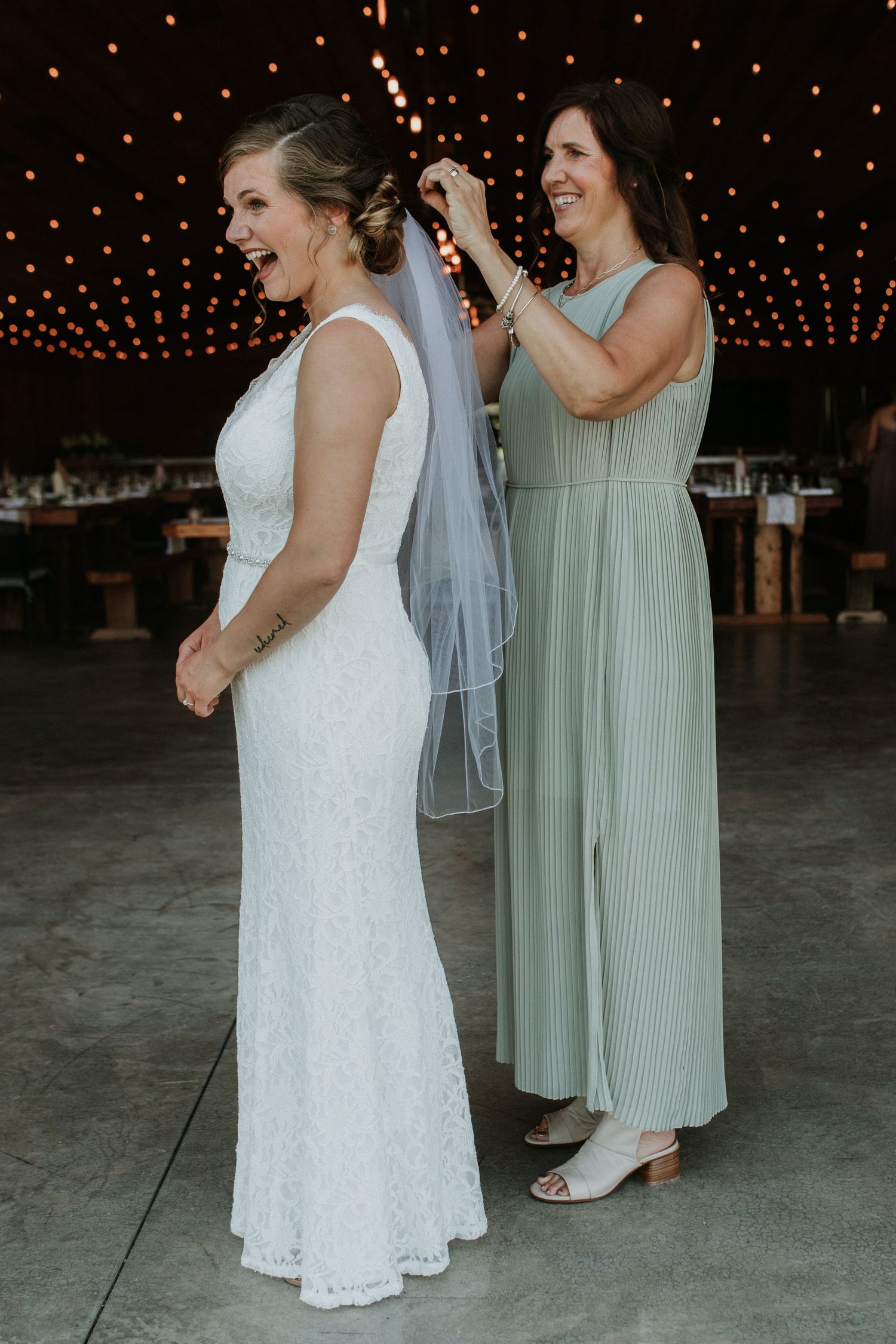 Bride with a huge smile and her mom fixing her veil