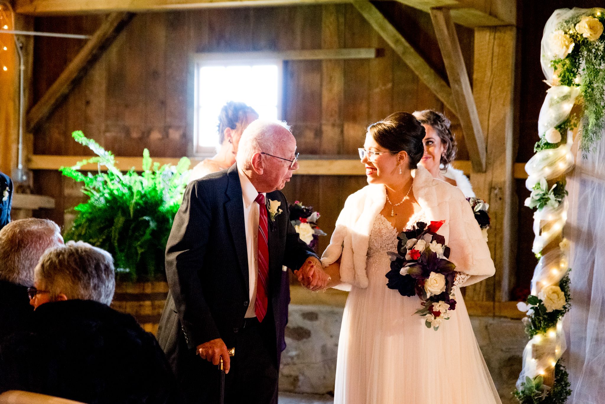 bride smiling at her grandfather before they pray for their fall barn wedding in Ohio
