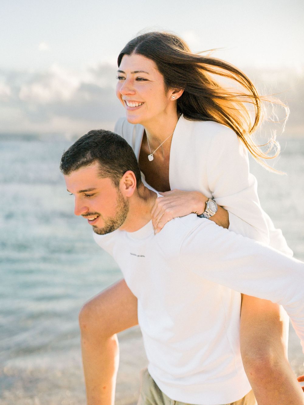Jeune femme sur le dos de son chéri. Photo de couple sur la plage de Saint Anne, Guadeloupe