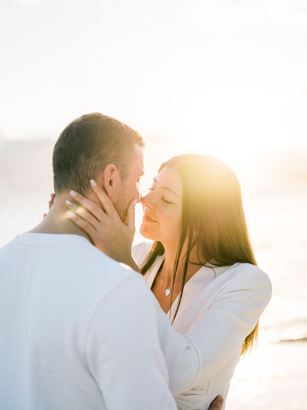 Couple qui s'embrasse devant le coucher du soleil