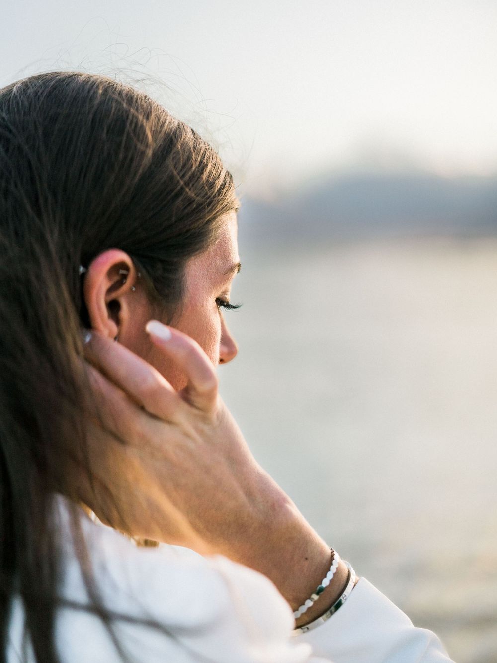 Jeune femme qui se recoiffe au bord de la mer