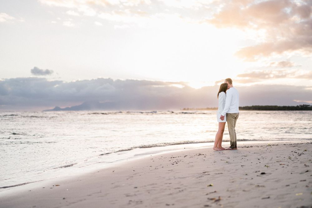 Couple qui s'embrasse sur une plage de Guadeloupe avec le relief de la soufrière en fond