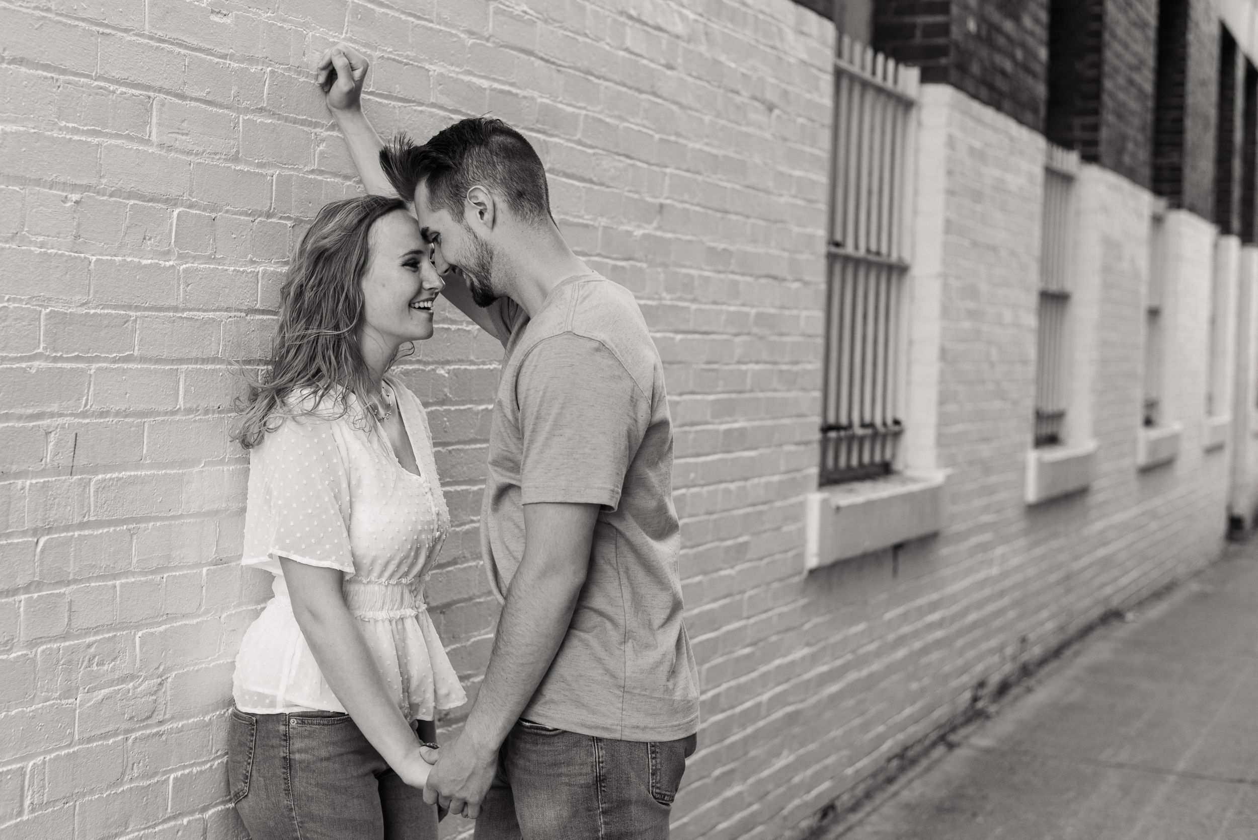 Couple leaning in alleyway in black and white for engagement in Franklin Pennsylvania