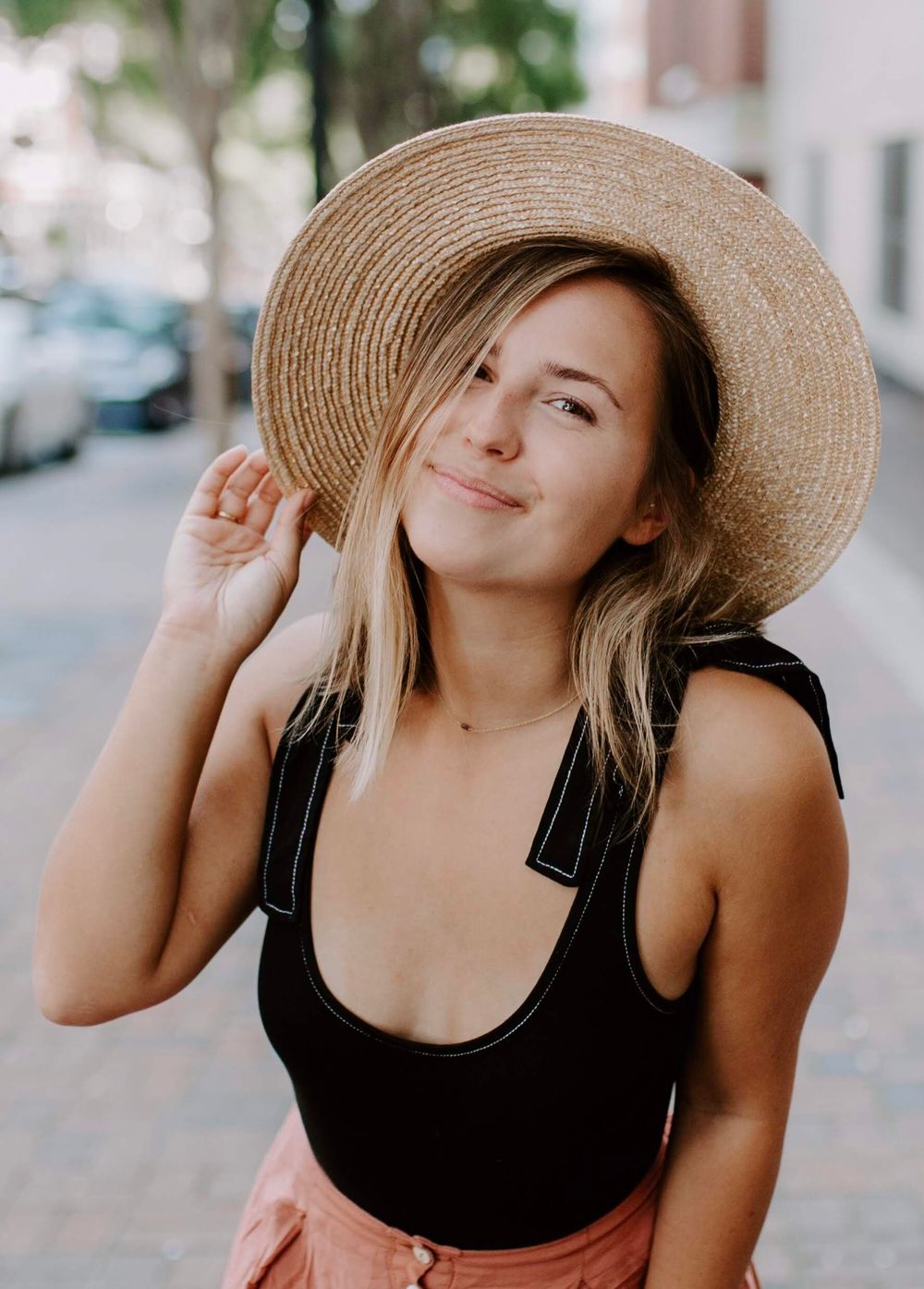 girl smiling wearing a straw hat at a Destin, FL wedding venue
