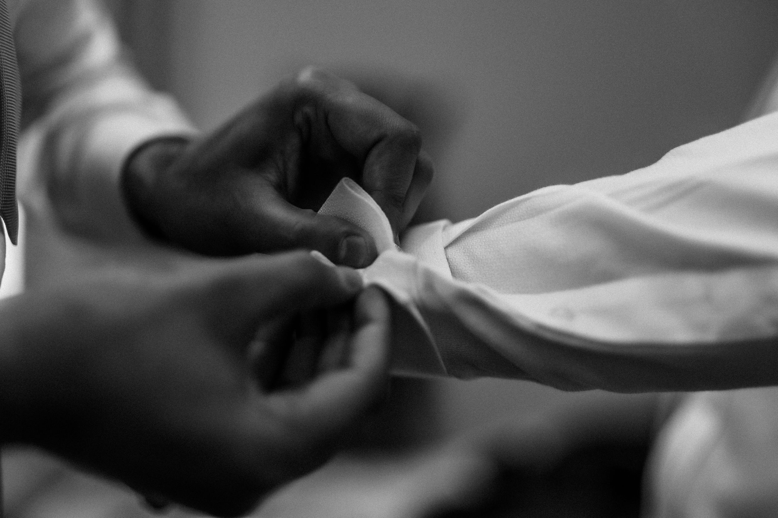 Black and white photo of grooms men getting ready before wedding in Wales