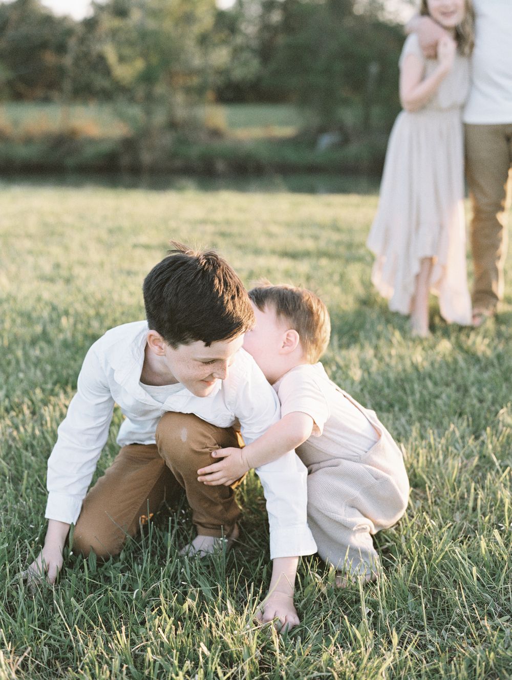brothers wrestle together in the grass