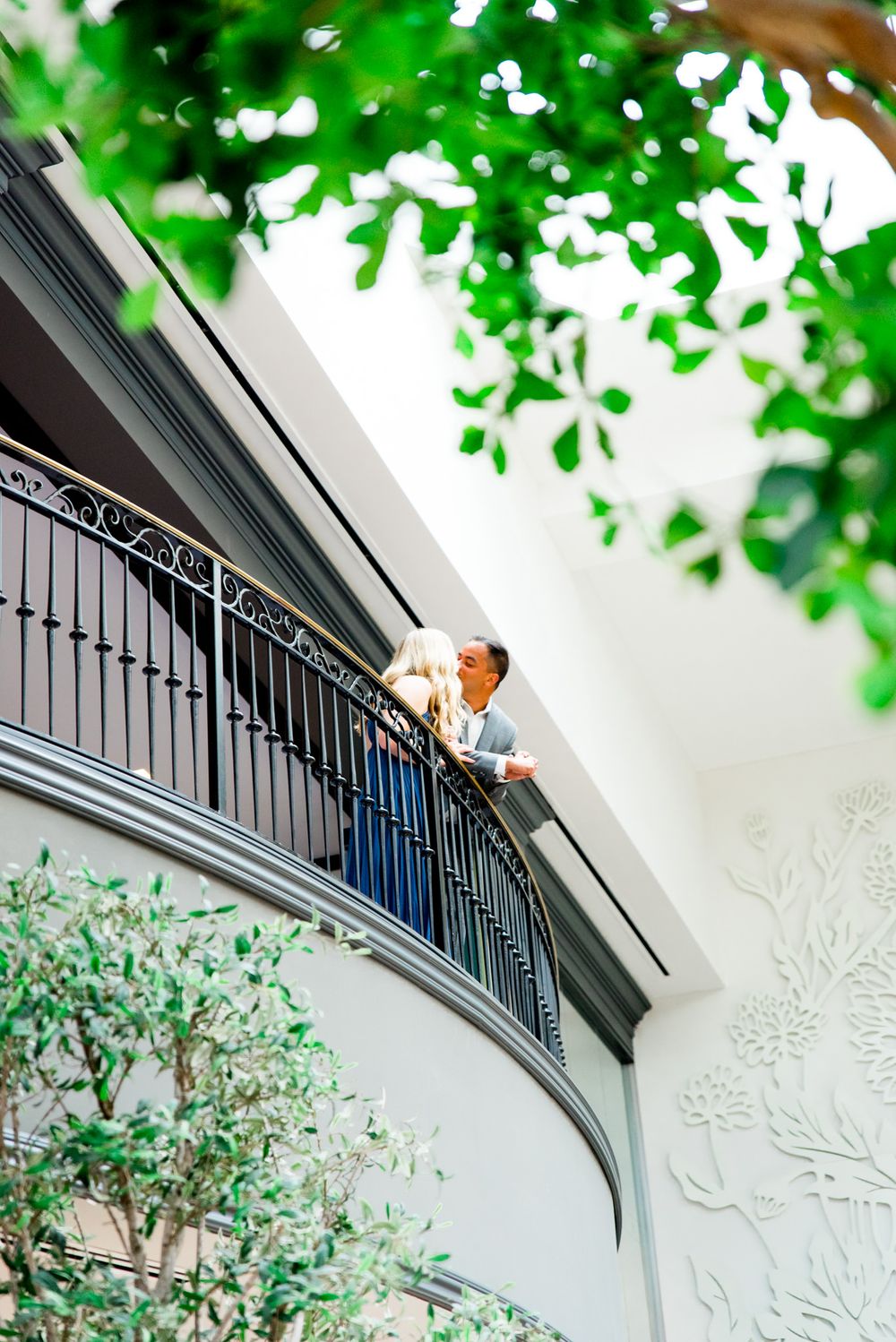 young couple kisses at Juliet balcony at Lytle Park Hotel atrium