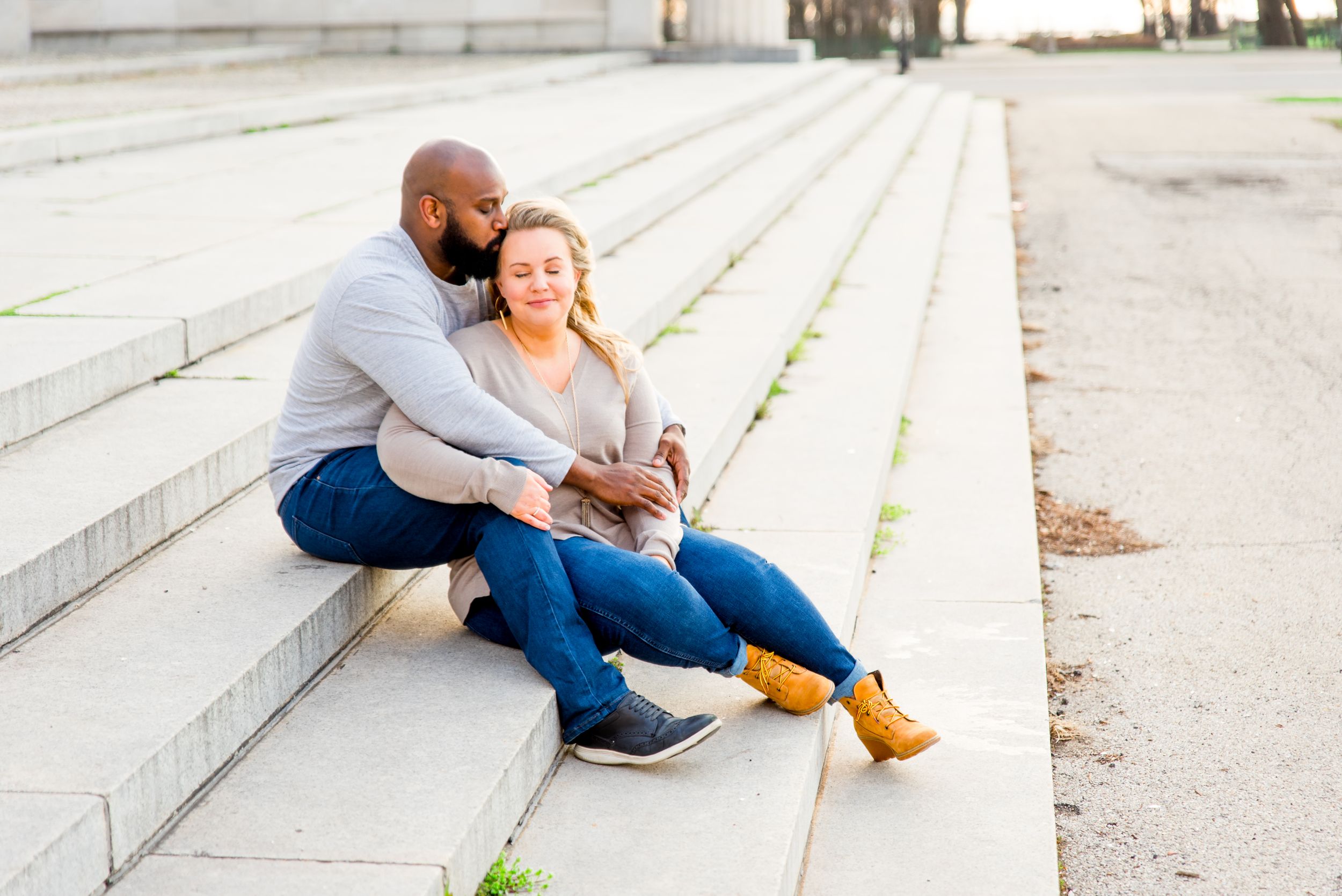 young couple sitting on steps in Grant Park for sunrise engagement pictures in CHicago