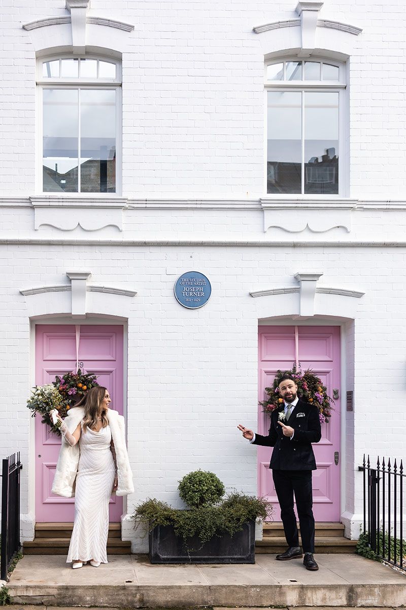 Couple portrait outside pink front doors in Chelsea London.