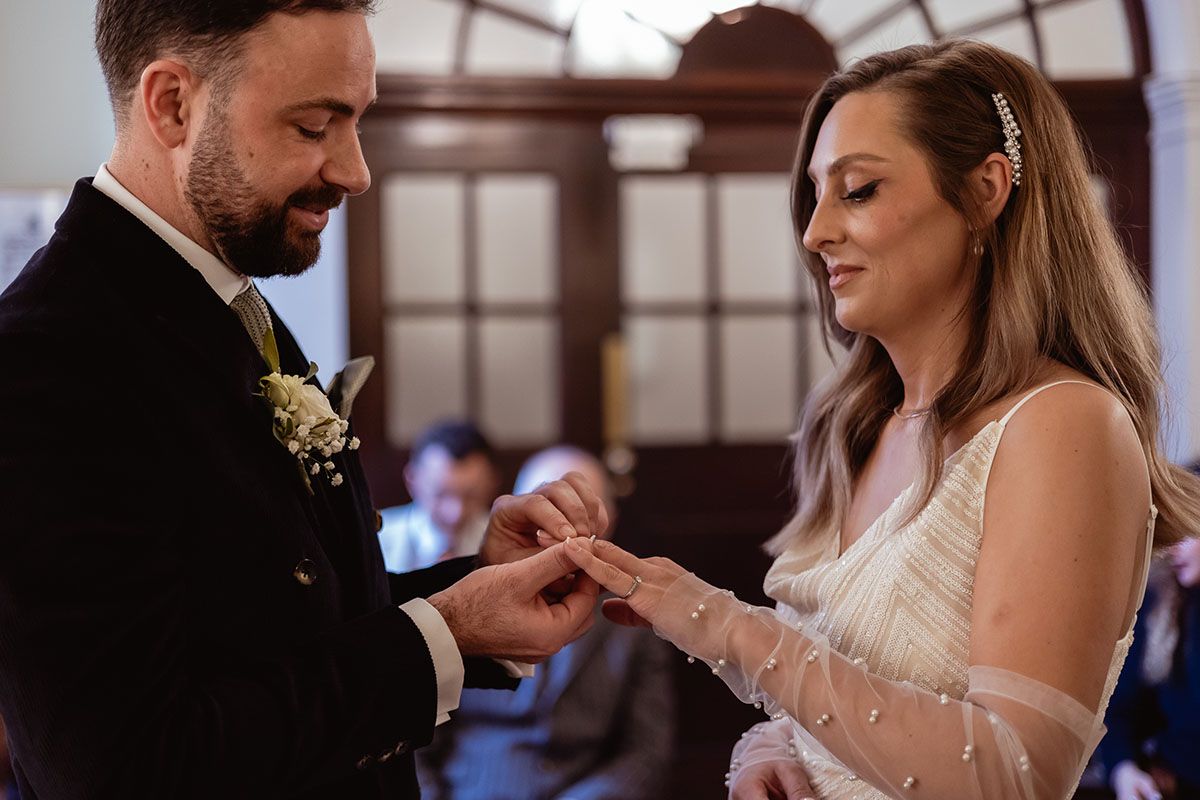 Exchanging of rings during wedding ceremony at London registry office.
