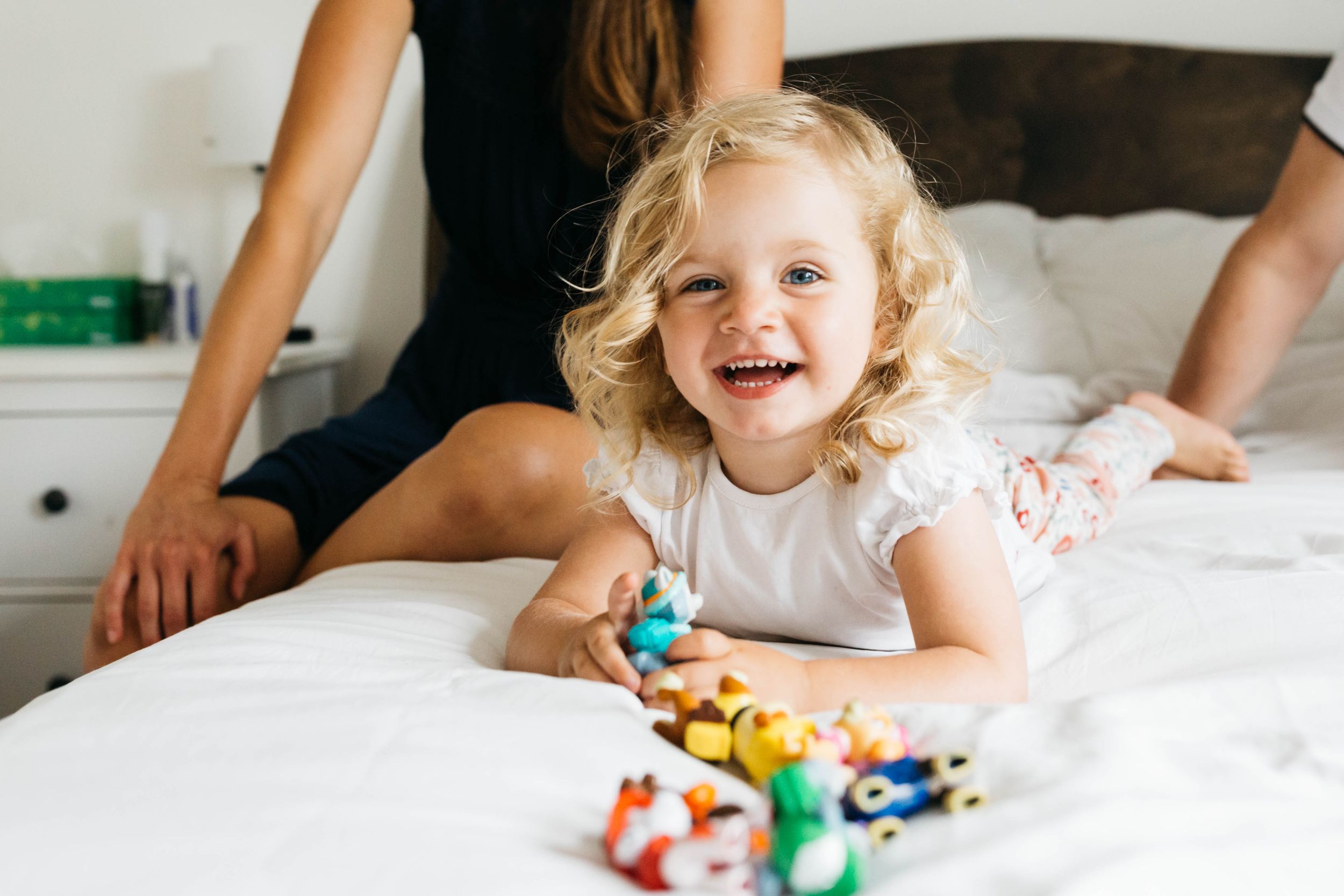 toddler girl with blonde curls laughing
