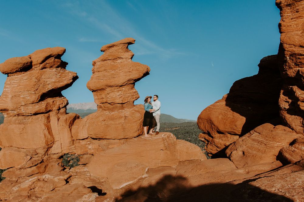 couple standing on rocks as the sunrises in Colorado springs
