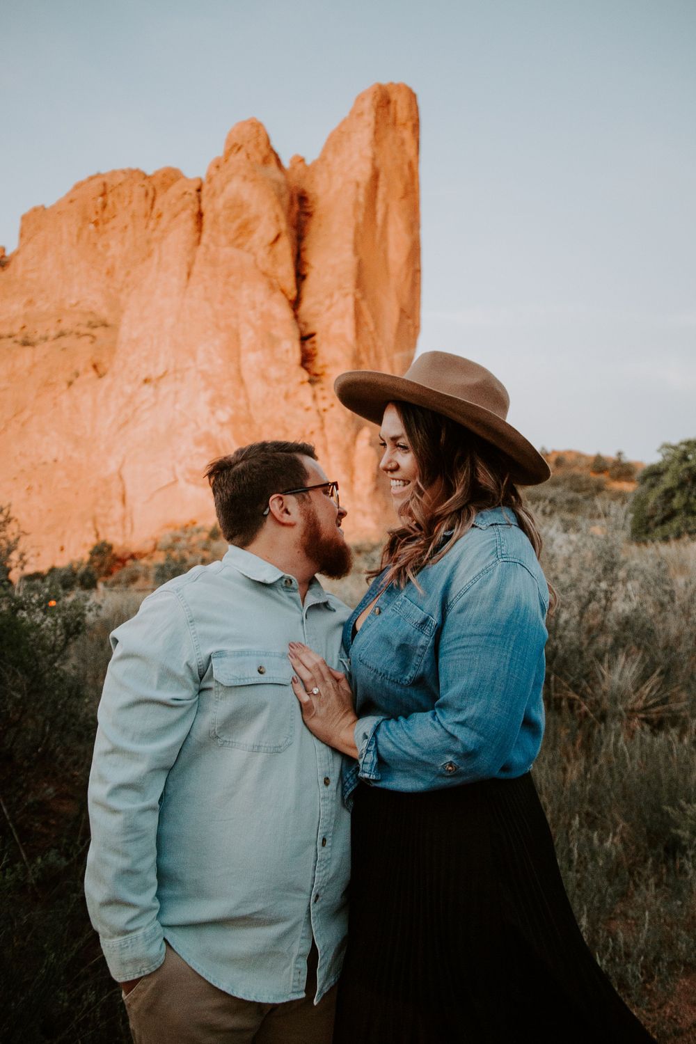 couple smiling standing in the Garden of the gods