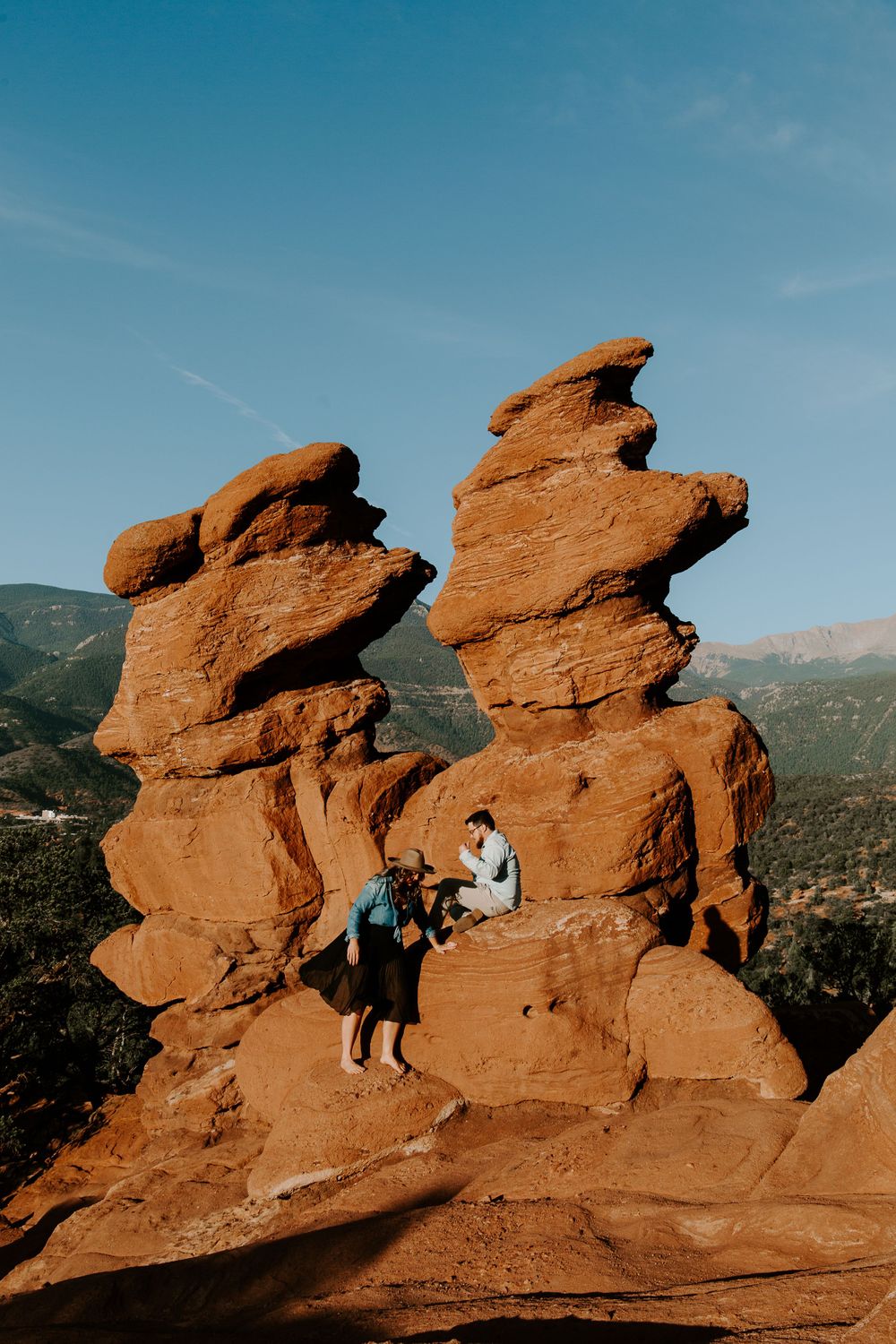 couple climbing on rocks in Colorado during their engagement