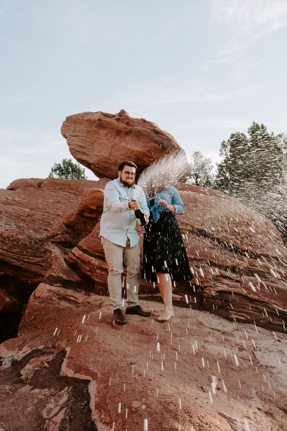 couple popping sparkling water during their adventurous couples session in Colorado Springs