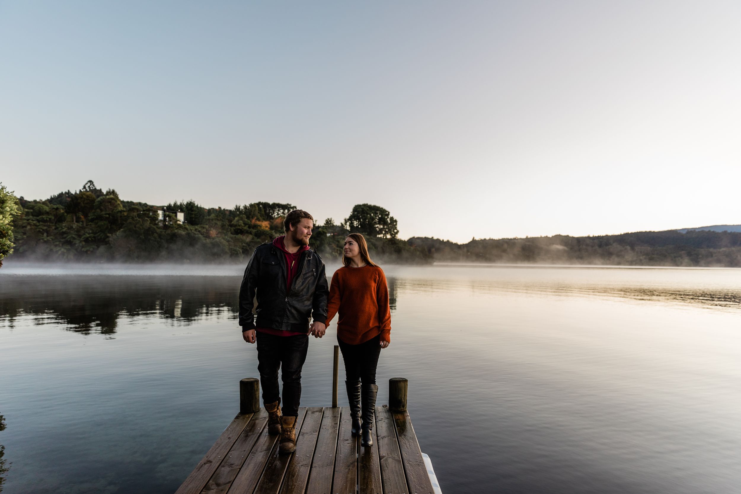 engaged couple walking along the jetty during blue hour