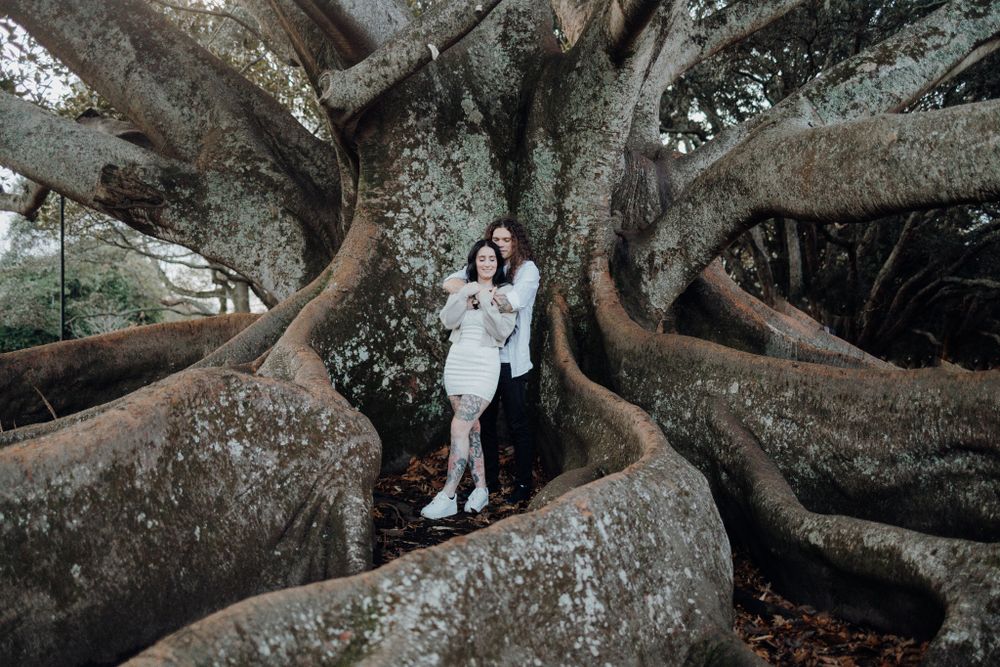 Artistic portrait among massive tree roots in an enchanting forest setting.