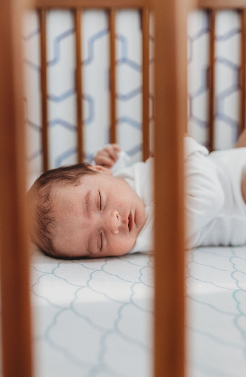 Baby boy sound asleep in his crib Chicago newborn lifestyle photo session
