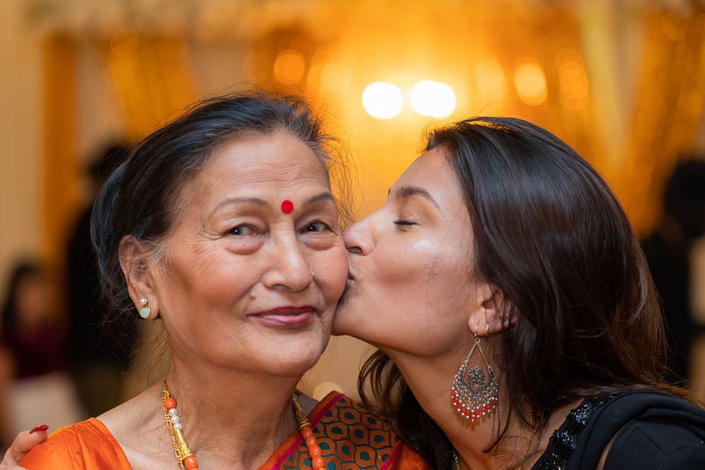 Two generations share an affectionate moment at formal cultural celebration.
