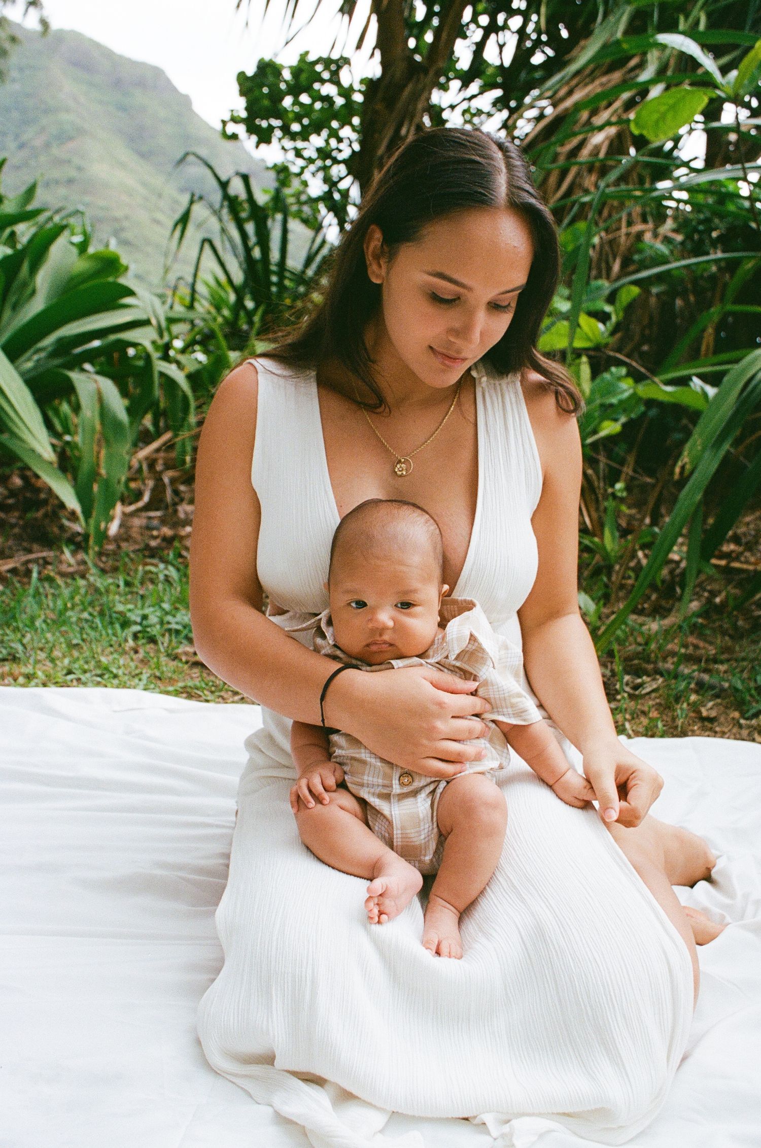 Mother lovingly holds baby against breathtaking Oahu backdrop