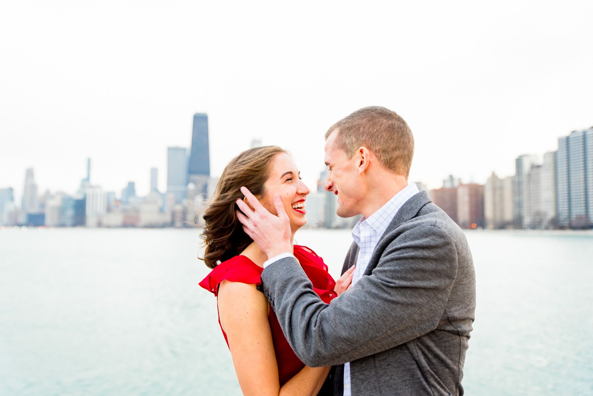 engaged couple looks at each other at North Avenue Beach engagement pictures on windy day