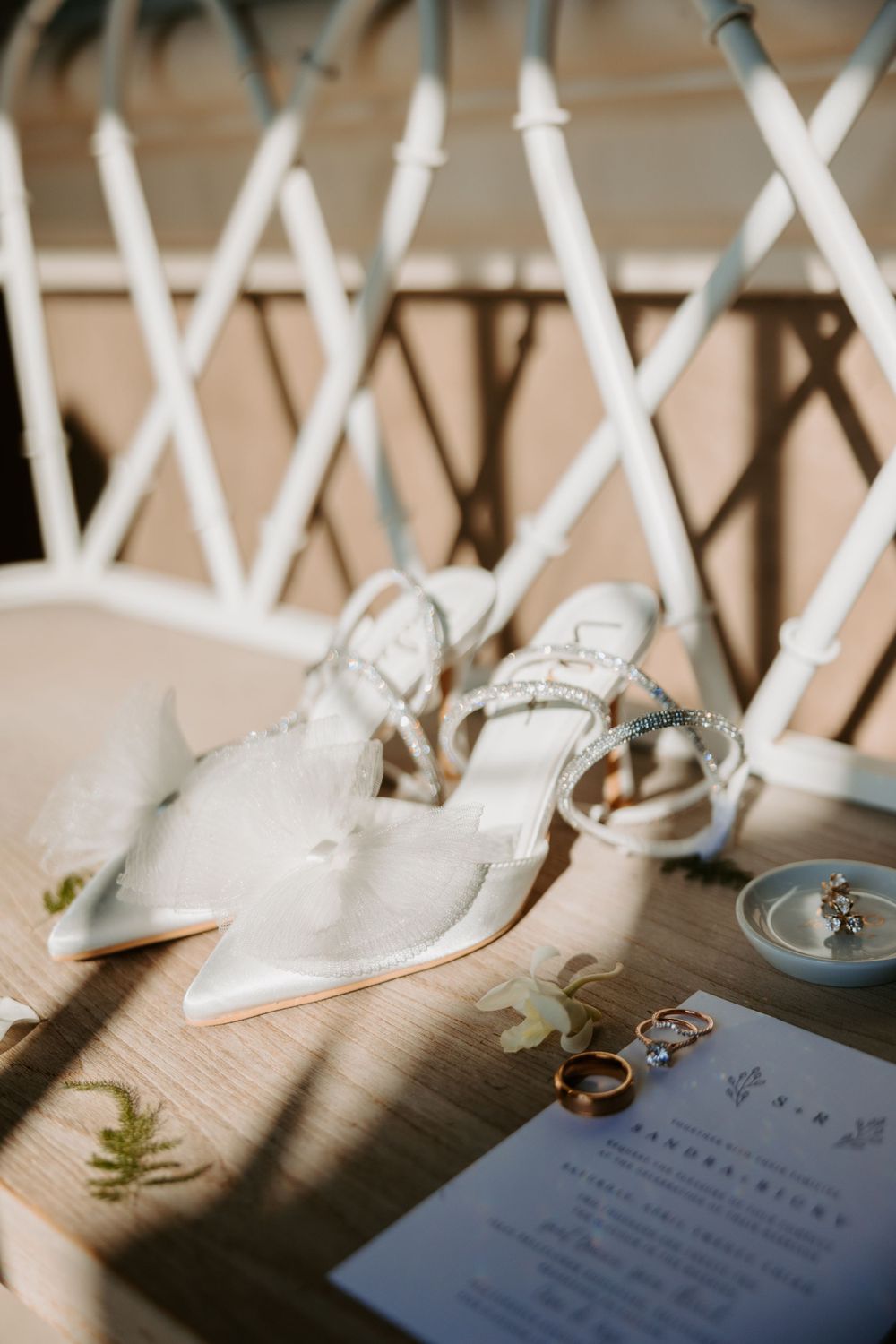Bride's wedding shoes placed next to invitations in Orange County