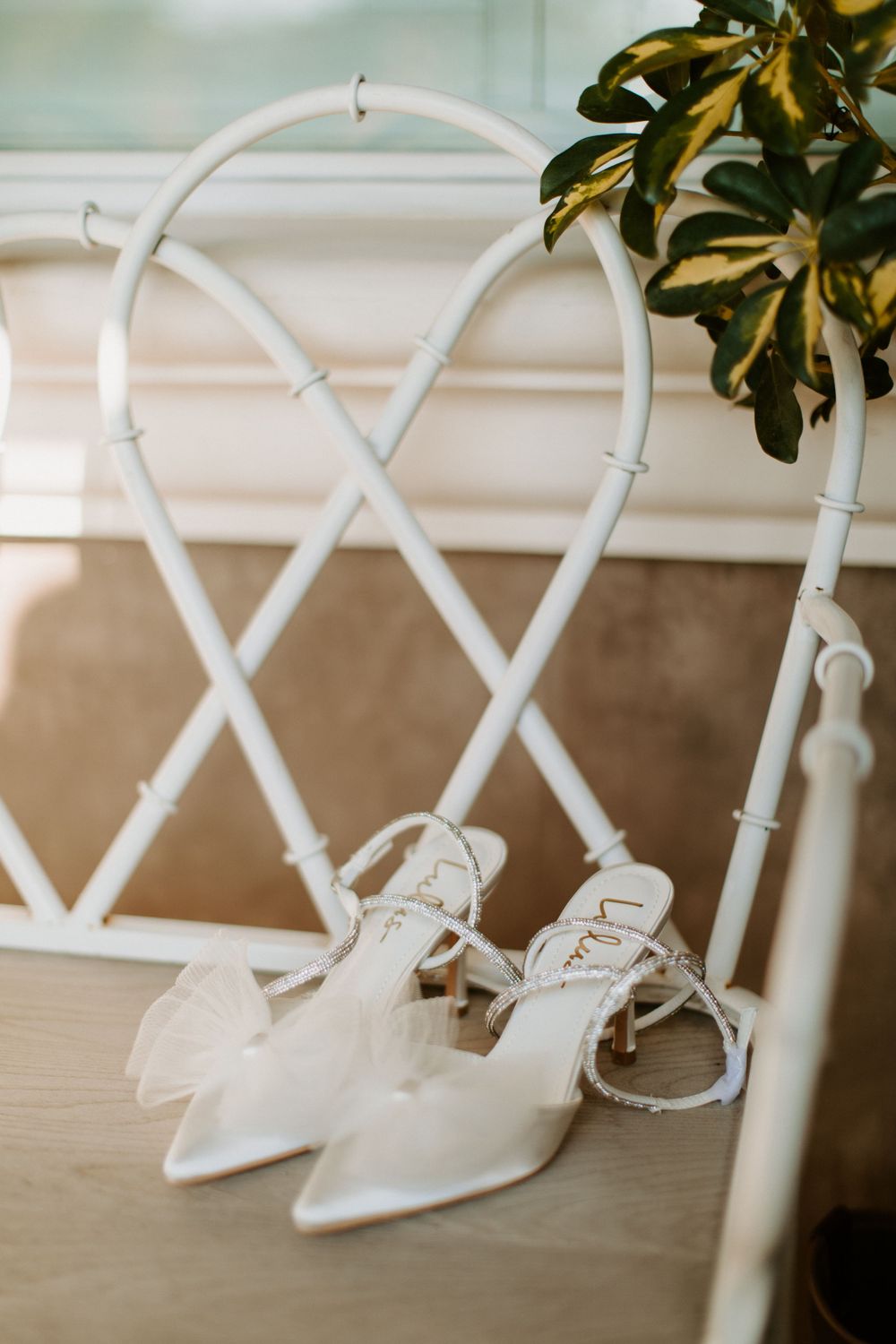 Bride's shoes placed on white chair, captured by Corazon Photography