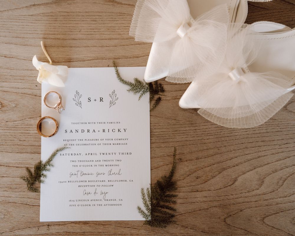 Flat lay shot of wedding invitations and ring, captured by Corazon Photography
