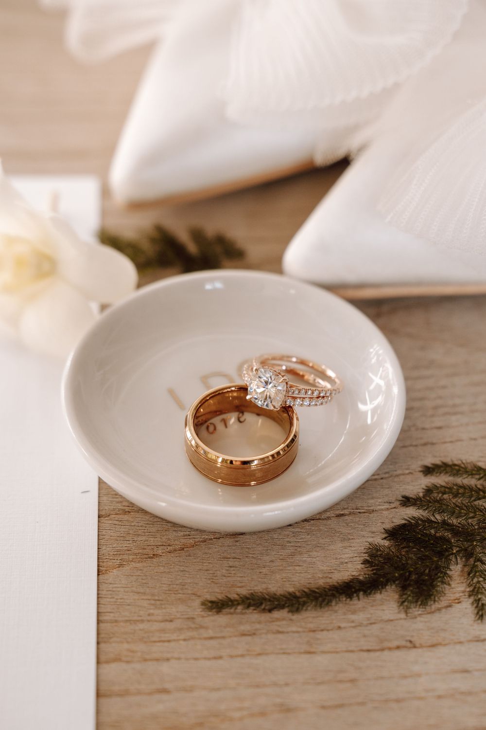 Close-up shot of gold wedding rings on white plate for luxurious wedding at Casa de Lago