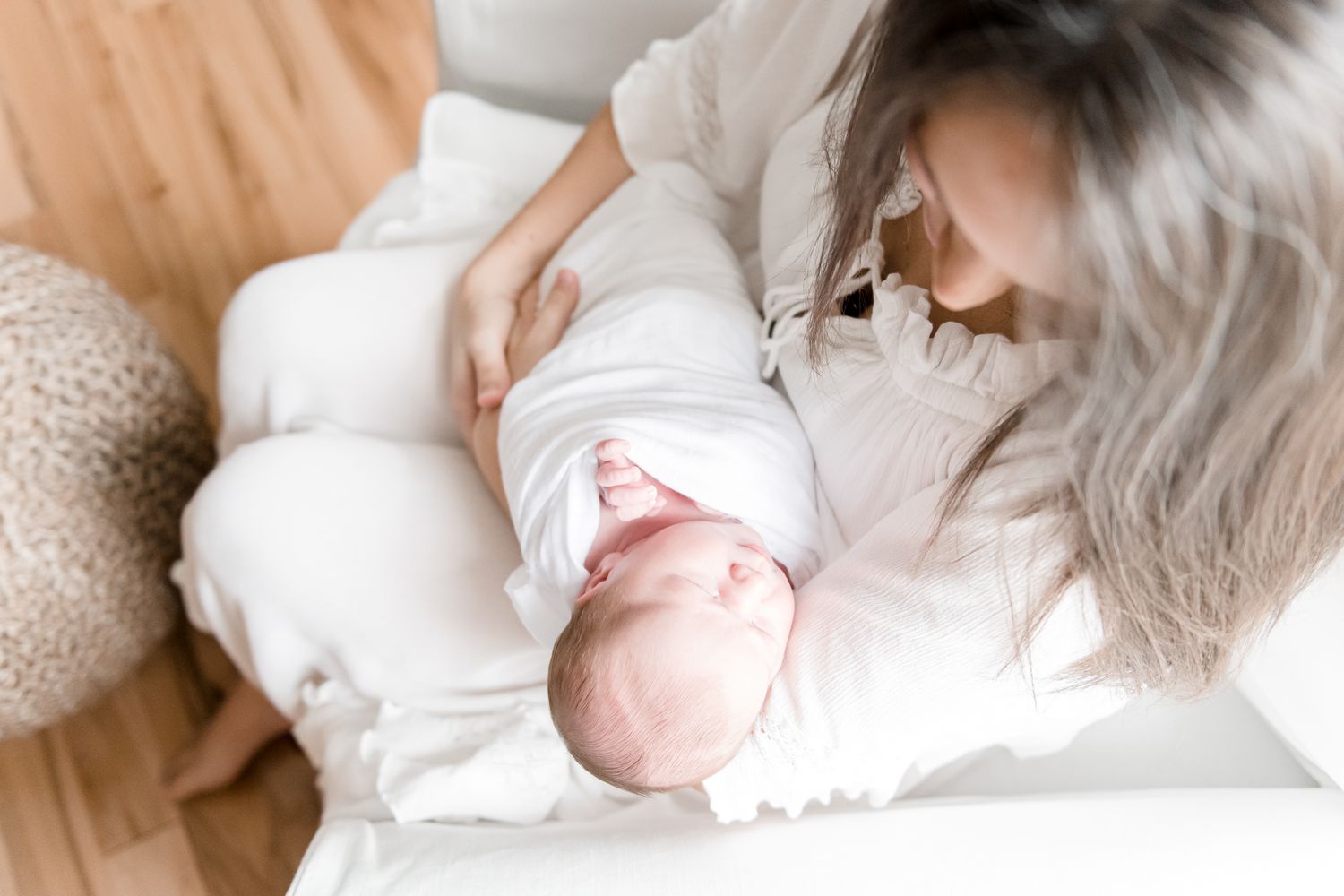 Mother holds newborn baby in her rocking chair