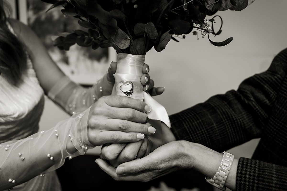 Close up photo of brides bouquet of flowers with her mother's ring attached, as her something borrowed.