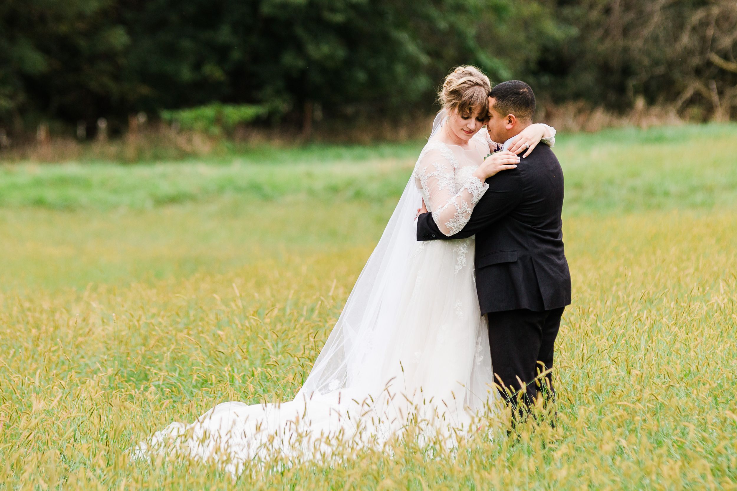 Bride and groom standing in a field of grass by Hudson Valley photographer