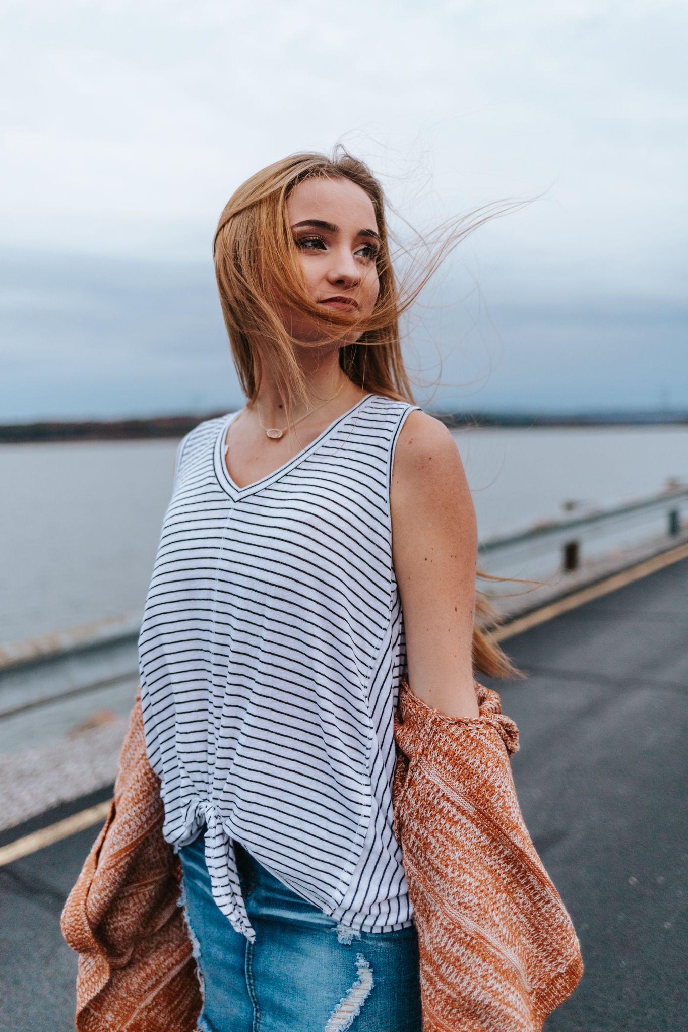 Moody senior portrait next to a lake