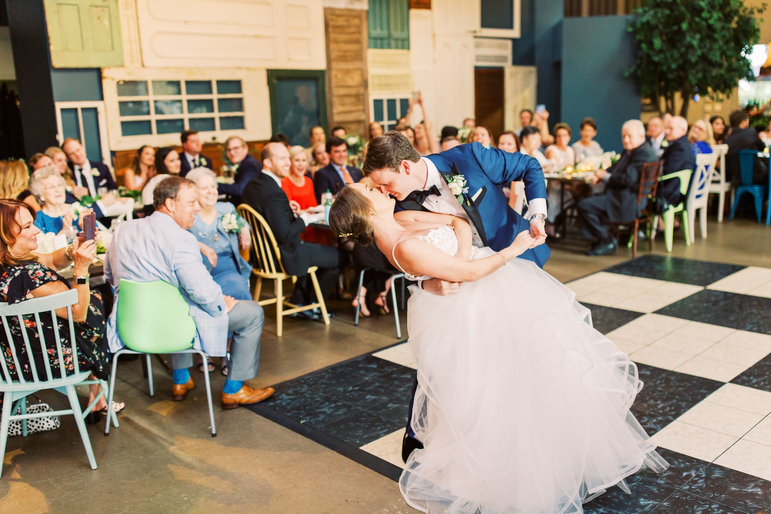 bride and groom dip kiss during their first dance at their soho south cafe wedding reception in savannah, ga